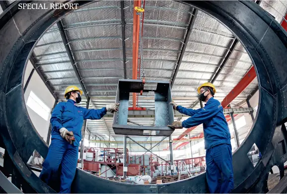  ??  ?? Workers speed up the processing of the building materials and equipment orders in the Shenghui machine workshop – a private enterprise at Baidian Town of Hai’an City in Jiangsu Province on May 17.