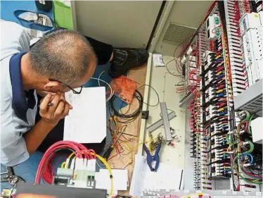  ??  ?? Attention to detail: An employee working on the main control system of heat recovery.