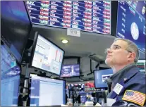  ?? AP PHOTO ?? Trader Anthony Rinaldi follows stock activity Monday at the New York Stock Exchange.