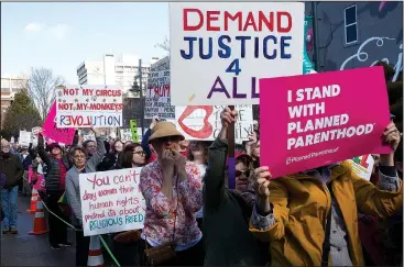  ?? NWA Democrat-Gazette/CHARLIE KAIJO ?? Supporters gather Saturday holding signs during a rally at Fayettevil­le’s Town Center. Supporters commemorat­ed the anniversar­y of the Fayettevil­le Women’s March with inspiratio­nal speakers. Later the group marched east down Mountain Street and up...