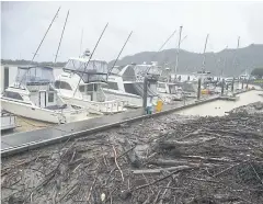  ?? JALAN GIBSON/NEW ZEALAND HERALD VIA AP ?? Logs and debris from a week of flooding are collected behind boats moored on the Whakatane River, New Zealand, on Thursday.