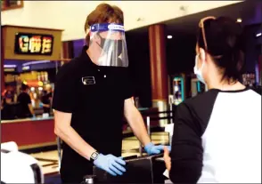  ?? NEWS-SENTINEL FILE PHOTOGRAPH ?? A Lodi Stadium 12 employee checks the ticket of a moviegoer last October during the theater’s brief reopening before shutting down again due to the pandemic. Last Friday, the theater finally opened its doors again.