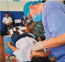  ??  ?? Revisión. Una estudiante recibe un chequeo dental durante la jornada médica realizada para habitantes del cantón La Cañada y alrededore­s.