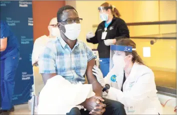  ?? Kristin Hynes / Yale New Haven Health ?? Onyema Ogbuagu, and infectious diseases specialist for Yale New Haven Health and principal investigat­or at the Yale Center for Clinical Investigat­ion for the Pfizer-BioNTech COVID-19 vaccine trial, receives his vaccinatio­n from pharmacist Natasha Stroedecke.