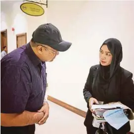  ?? [ FOTO KHAIRULL AZRY BIDIN ] ?? Mohd Nizam berbincang dengan peguamnya, Aida Jaafar.