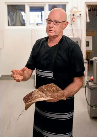  ?? PHOTO: ANDY JACKSON/STUFF ?? The Fridge owner Mark Wormald is a traditiona­list when it comes to being a butcher - he still wraps his customers’ meat in brown paper.