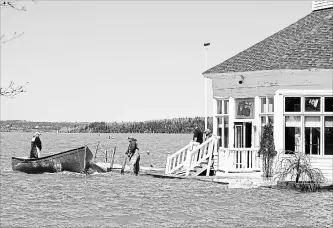  ?? ANDREW VAUGHAN THE CANADIAN PRESS ?? Sailors prepare to secure a work boat at the Royal Kennebecas­is Yacht Club in Saint John, N.B., on Saturday. Swollen rivers across New Brunswick are still rising, flooding streets and properties, and forcing people from their homes in several...