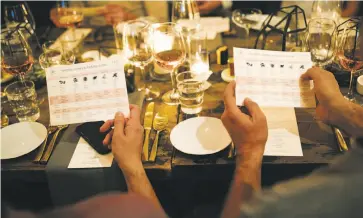  ?? Photos by Mason Trinca / Special to The Chronicle ?? Jamie Evans, from top, at the wine, cannabis and food pairing event in S.F.; guests study a terpene aroma and tasting guide; a diner drizzles cannabis-infused olive oil, Pot d’Huile, onto her appetizer.