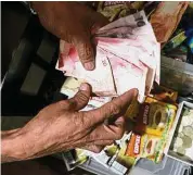  ??  ?? Low peso: A man counting peso bills inside a store in Manila recently. The peso has sunk to a 2005-low this month. — Bloomberg