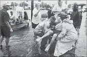  ?? Steve Gonzales Associated Press ?? NEIGHBORS use their personal boats to rescue a resident of Friendswoo­d, Texas, on Sunday.