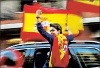  ??  ?? ‘RESIST’: An anti-separatist activist waves the Spanish flag in the Catalonia capital of Barcelona Saturday.