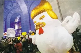  ?? Michael M. Santiago/Post-Gazette ?? Protesters display an inflatable chicken designed to resemble President Donald Trump during a rally Thursday at the City-County Building, Downtown.