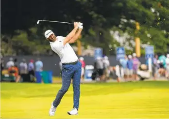  ?? CHARLIE RIEDEL AP ?? Dustin Johnson watches his shot on the first hole during the second round of the U.S. Open on Friday.