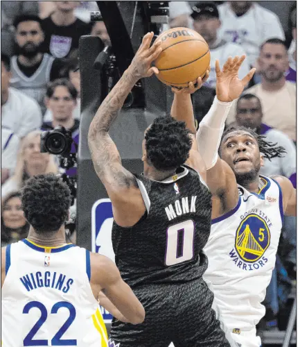  ?? Jose Luis Villegas The Associated Press ?? Kings guard Malik Monk lines up a shot against Warriors forwards Kevon Looney and Andrew Wiggins in Sacramento’s win Saturday at Golden 1 Center. Monk scored 32 points, hitting 14 of 14 free throws.