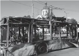  ?? — AP ?? A burned trolley bus is seen near Donetsk train station after shelling by unknown fighters in Donetsk, Ukraine, on Saturday.