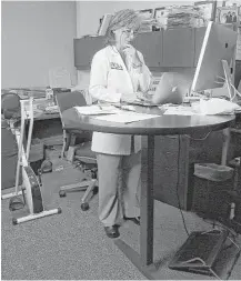 ?? Karen Warren / Houston Chronicle ?? Researcher­s say you burn 15 percent more calories using standing desks.
