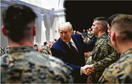  ?? Al Drago / New York Times ?? President Donald Trump greets Marines during a visit to the Marine Barracks on Thursday in Washington. The president apologized for not visiting Arlington last week, citing his tight schedule after visiting the American cemetery in Paris.