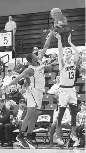  ?? KENNETH K. LAM/BALTIMORE SUN ?? UMBC’s Joe Sherburne, right, shoots a 3-pointer last season over Coppin State’s Adam Traore. Sherburne helped the Retrievers earn a stunning NCAA tournament win.