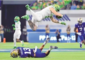  ?? DAVID BECKER / ASSOCIATED PRESS ?? Oregon tight end Terrance Ferguson (3) is tripped up by Washington cornerback Kamren Fabiculana­n (13) during Friday’s Pac-12 championsh­ip in Las Vegas, Nev.