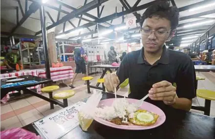  ?? WAHID PIC BY ROSDAN ?? A student eating ‘nasi bujang’ at an outlet at Universiti Malaya in Kuala Lumpur recently.