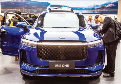  ?? PROVIDED TO CHINA DAILY ?? Visitors check out a Li Auto electric car during an automobile exhibition in Shanghai.