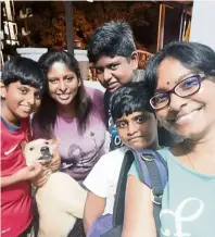  ??  ?? a few months after his rescue, an energetic coco is the centre of attention, surrounded by his new family and the writer (right). — Photos: VaNITha LOGaNaThaN