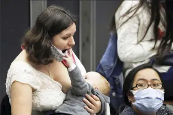  ?? AP photo ?? Valentina Frey of Switzerlan­d breasts feed her daughter, Charlotte Katharina, in the Paul VI hall on the occasion of the weekly general audience at the Vatican. Released Tuesday, the first U.S. government dietary guidelines for infants and toddlers recommend exclusive feeding of breast milk for at least six months and no added sugar for children under age 2.