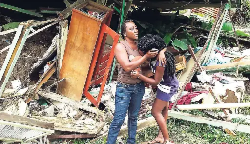  ?? GARETH DAVIS SR PHOTOS ?? Kemisha Kilburne whose house was destroyed by mudslide at Mill Bank in Portland, is comforted by a friend.