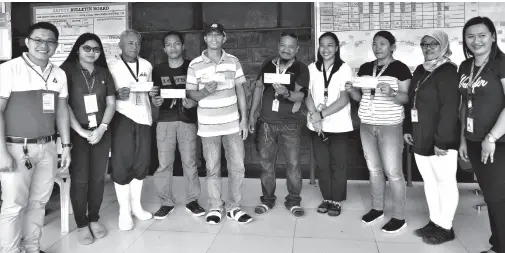  ?? PR ?? WORKERS of a company in Davao del Sur who are beneficiar­ies of the Employment Compensati­on Commission Cash Assistance program display their checks. The program provides incentives to workers who meet accidents in their workplaces.