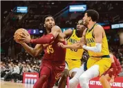  ?? Phil Long/Associated Press ?? The Cleveland Cavaliers’ Donovan Mitchell (45) looks to shoot as the Indiana Pacers’ Tyrese Haliburton and Doug McDermott defend during the first half in Cleveland last Friday.