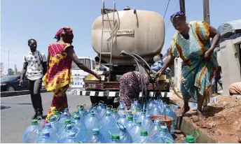  ?? ?? Senegalese women fill water bottles from a tanker truck during a public distributi­on in Dakar.