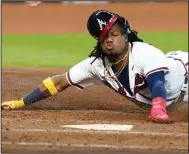  ?? (AP/Eric Gay) ?? Ronald Acuna Jr. of the Atlanta Braves slides into home to score a run during the Braves’ victory over the Miami Marlins in Game 1 of their National League division series Tuesday in Houston.