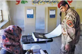 ??  ?? THAIER AL-SUDANI/REUTERS An Iraqi security member casts his vote at a polling station two days before polls open to the public in a parliament­ary election in Baghdad, Iraq on May 10, 2018.