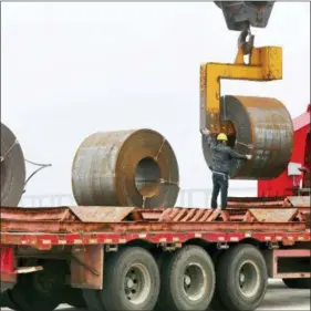  ?? CHINATOPIX VIA AP ?? In this May 2018, photo, a worker positions a roll of steel plate at a dockyard in Qidong in eastern China’s Jiangsu province. China appealed Friday to its trading partners to reject “trade and investment protection­ism” after Washington raised tariffs...