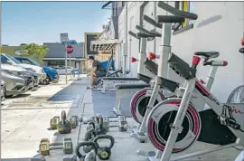  ?? Jarrod Valliere San Diego Union-Tribune ?? ERIK SALCEDO takes a break at the Last Real Gym’s sidewalk setup in San Diego. A new proposal would make it easier for gyms to operate at county parks.