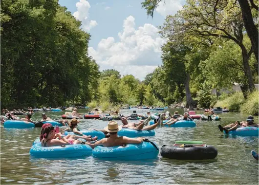  ?? ELI DURST/THE NEW YORK TIMES PHOTOS ?? Tubers float down the Guadalupe River, which has a few rapid stops and appeals to both young and old, Aug. 27 in Gruene, Texas.