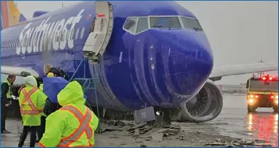  ??  ?? 圖中可見西南航空的波­音737客機，在滑出跑道後，終於停了下來，但航機已經「跪下」，著陸使用的著陸架和輪­胎都已毀壞，不見了，整個客機則平躺在地上。 （取自推特）