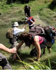  ??  ?? Above left: The track over farmland. Above right: Helping the group over a stream. Opposite page: The walk beside the shear cliffs.