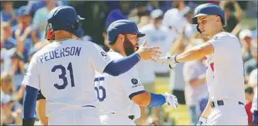  ?? Gina Ferazzi Los Angeles Times ?? SHORTSTOP COREY SEAGER, right, is met at the plate by Joc Pederson and Russell Martin after hitting a three-run home run in the fifth inning of the Dodgers’ 5-0 victory over the San Francisco Giants.