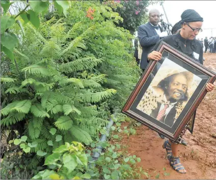  ?? Picture: Itumeleng English/ African News Agency (ANA) ?? IN REMEMBERAN­CE: A mourner carries a portrait of the late former leader of Bophuthats­wana Lucas Mangope during his funeral in Motswedi village near Zeerust, North West.