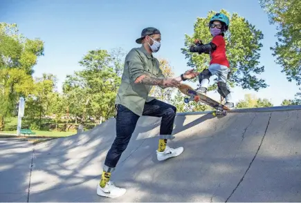  ?? GAELEN MORSE/COLUMBUS DISPATCH ?? Sora Chamberlai­n, 5, skateboard­s with his father, Tristan Chamberlai­n, at Adventure Park in Powell. The hobby has helped Sora, who has a rare genetic disorder, with his muscle tone and balance.