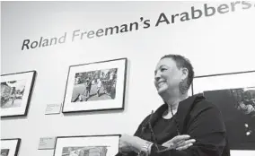  ?? BARBARA HADDOCK TAYLOR / BALTIMORE SUN ?? Jackie Copeland, executive director of the Reginald F. Lewis Museum, stands among the photograph­s of arabbers taken by Roland Freeman.