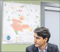  ?? CP PHOTO ?? A map of evacuation orders and alerts hangs on a wall as Prime Minister Justin Trudeau listens during a meeting with British Columbia Wildfire Service staff and other officials during a visit to the Prince George Fire Centre, in Prince George, B.C., on Thursday.