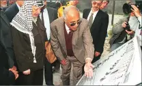  ?? Picture: RON WIGLEY ?? PALESTINIA­NS: Ahmed Kathrada shows Yasser Arafat a photograph of himself at work in Robben Island.