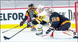  ??  ?? Pittsburgh Penguins’ Sidney Crosby, (left), reaches for the puck in front of Philadelph­ia Flyers goaltender Carter Hart, (right), during the first period of an NHL hockey game, on Jan 15, in Philadelph­ia. (AP)