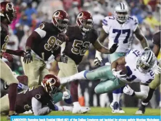  ??  ?? LANDOVER: Running back Ezekiel Elliott #21 of the Dallas Cowboys get tackled by strong safety Montae Nicholson #35 of the Washington Redskins during the third quarter at FedEx Field in Landover, Maryland.— AFP