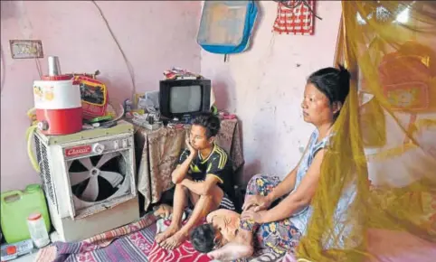  ?? SAUMYA KHANDELWAL/HT PHOTO ?? Myanmarese refugee Joseph Khar, 32 (left), with his wife Ngaideilum and daughter at their rented house in Bodella, West Delhi.