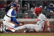  ?? JOHN BAZEMORE — THE ASSOCIATED PRESS ?? The Phillies’ Alec Bohm slides in ahead of the tag from Atlanta Braves catcher Travis d’Arnaud to score the winning run on a Didi Gregorius sacrifice fly in the ninth inning of a 7-6decision for the Phils Sunday. Or at least, that’s the way the umpires and an official review saw it.