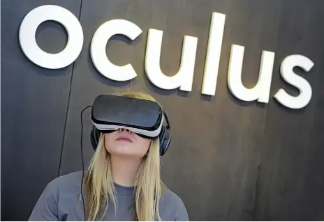  ??  ?? A woman uses an Oculus virtual reality device, which can show patients how drugs combat tumours