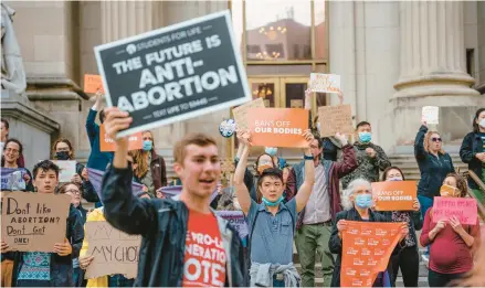  ?? JAMIE KELTER DAVIS/THE NEW YORK TIMES ?? Anti-abortion and abortion rights demonstrat­ors outside the federal courthouse in Indianapol­is in May 2022.